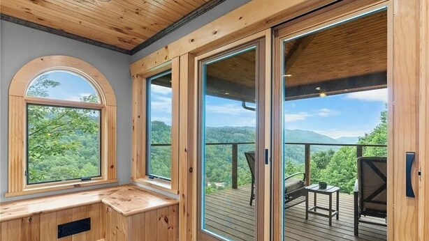 A wooden interior with large windows and a deck. - Family Friendly 3 Bear Cubs Cabin-Buck Mtn-EV Charger,AC,Views (Purlear)