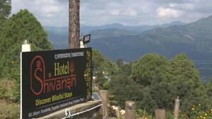 Schild für das Shivansh Hotel mit Blick auf die Berge im Hintergrund.
