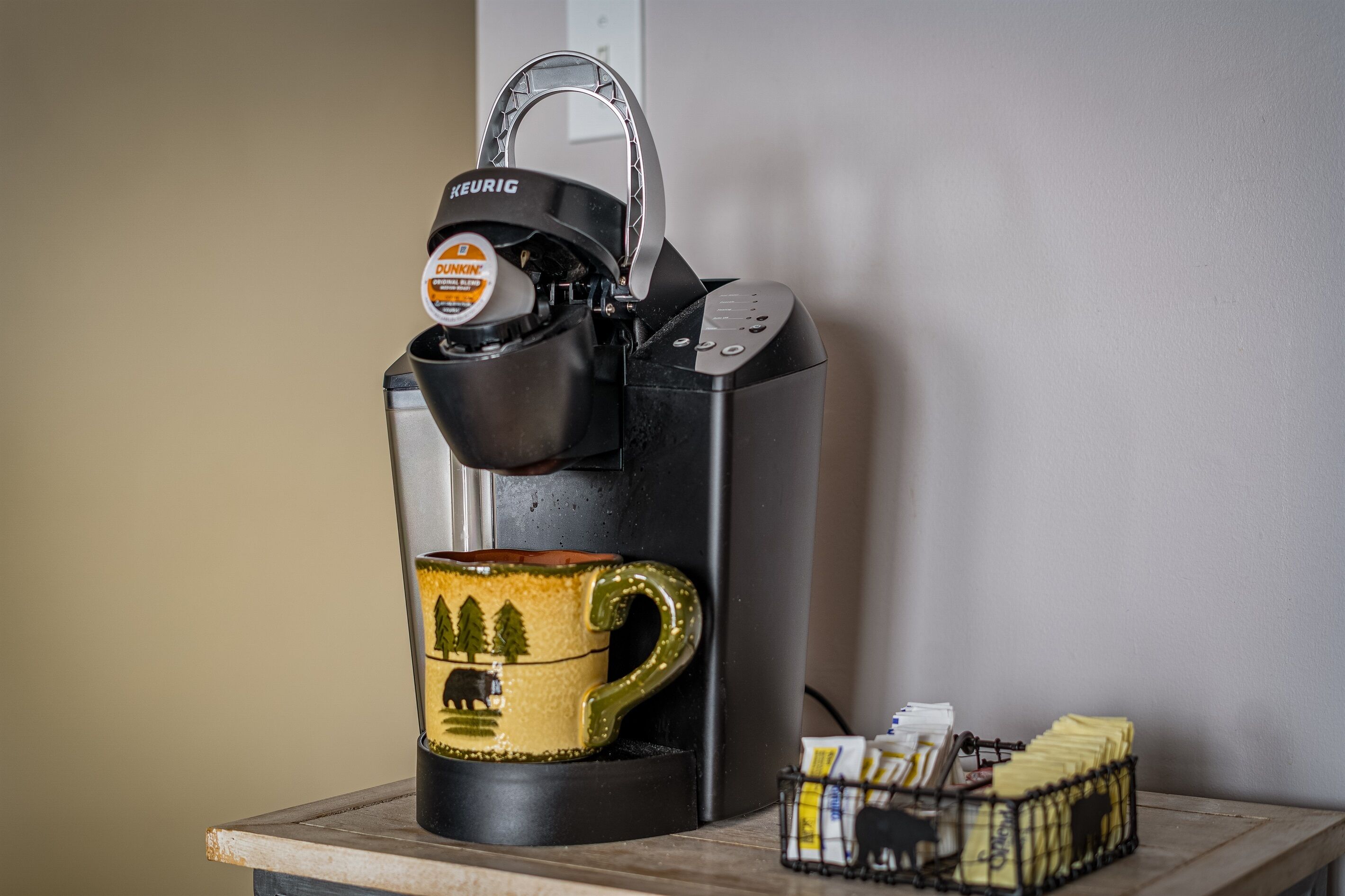 En Keurig-kaffemaskin med en mugg och kaffekapslar på en köksbänk.