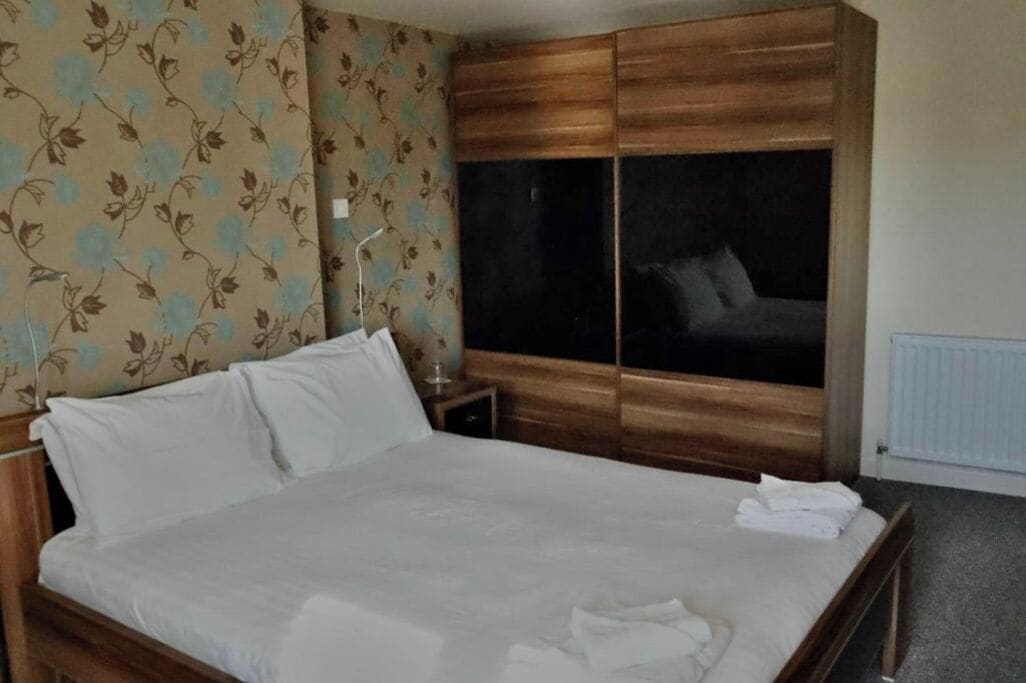 Une chambre d’hôtel avec un lit, une armoire et une fenêtre.