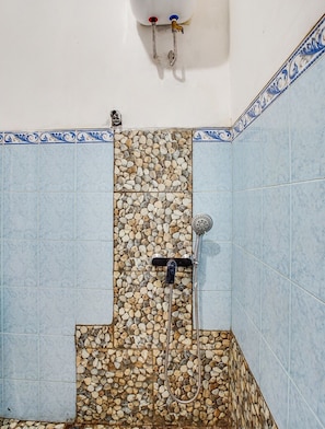 A bathroom with a shower area featuring a mosaic tile wall and a blue-tiled floor. - SPOT ON 91117 Sriwijaya Residence Syariah (Bandung)