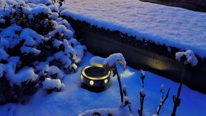 A snow-covered garden with a lantern, a Christmas tree, and a stone wall. - Oasis on the edge of the Black Forest m. Courtyard, garden, terrace and lots of play equipment (Malsch)