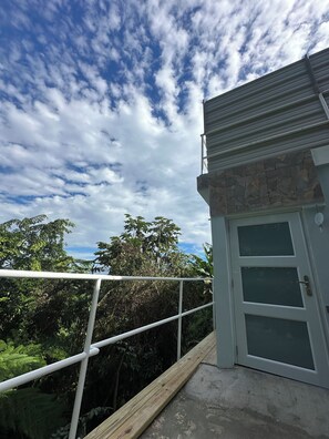 A balcony with a stone wall and a white door.