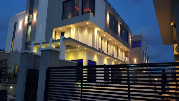 A modern two-story house with a balcony and multiple windows. - Kair Serviced Apartment (Benin City)