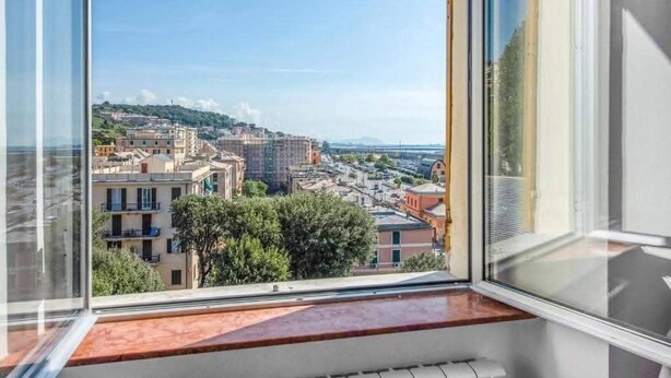 Ein Balkon mit Blick auf eine Stadtlandschaft, einschließlich Gebäude und Grünflächen.