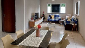 Una sala de estar moderna con comedor, televisión y un árbol de Navidad.