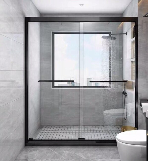 Un box de ducha moderno con puerta de cristal, un inodoro y un perchero para toallas.