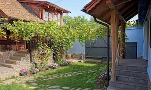 A rustic wooden house with a stone staircase leading to a wooden porch.
