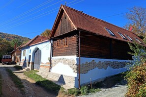 A traditional wooden house with a sloped roof and a stone foundation.