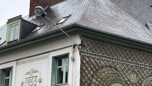 Un bâtiment dont la façade porte le numéro « 1935 », avec une porte de garage et une structure en treillis métallique sur le côté.