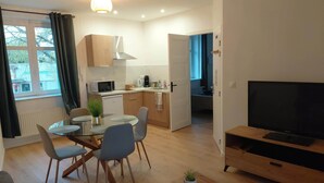 Un appartamento moderno con zona pranzo, cucina, soggiorno e televisore.
