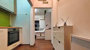 Uma cozinha moderna com forno embutido, relógio digital e um letreiro com a mensagem 'Bem-vindo a Casa'.