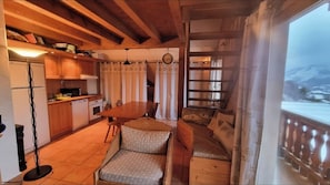 A cozy kitchen with wooden cabinets, a dining table, and a sofa. - Duplex 50m2 balcony panoramic T2 cosy Praloup 1500 (Uvernet-Fours)