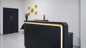 Mostrador de recepció amb acabat negre i un detall taronja il·luminat.