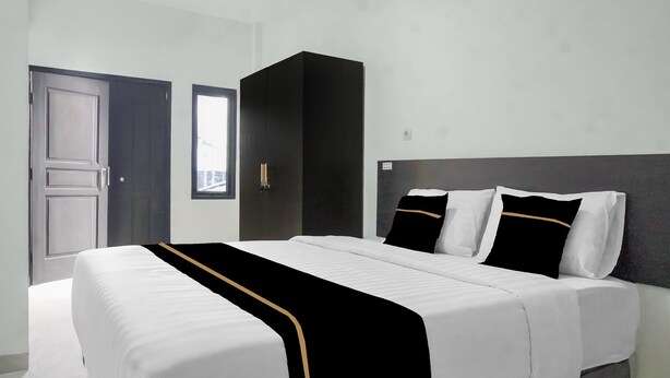 Habitació d'hotel amb llit, armari, porta i finestra.