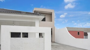 Un edifici modern de dues plantes amb teulada plana i un balcó.
