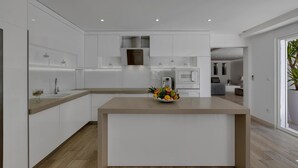 Een moderne keuken met witte kasten, een centraal eiland en een fruitschaal.