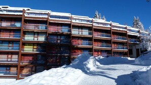 Un hotel de varios pisos con balcones, rodeado de nieve.