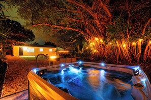 A hot tub with lights, surrounded by trees and a building with lights. - East Boca Getaway, Minutes to Beach & Downtown (Boca Raton)