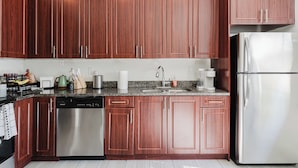 Una cocina moderna con armarios de madera, electrodomésticos de acero inoxidable y encimeras de granito.