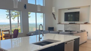 Una cocina moderna con una isla grande, electrodomésticos integrados y un ventanal con vistas panorámicas.