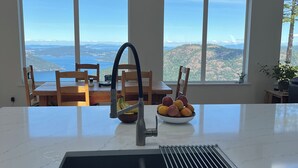 Una cocina con un ventanal amplio, un lavabo y un cuenco con fruta.