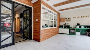 A reception area with a wooden accent wall, a reception desk, and a sign indicating a quarantine zone. - Collection O Yayah Residence  (Dramaga)