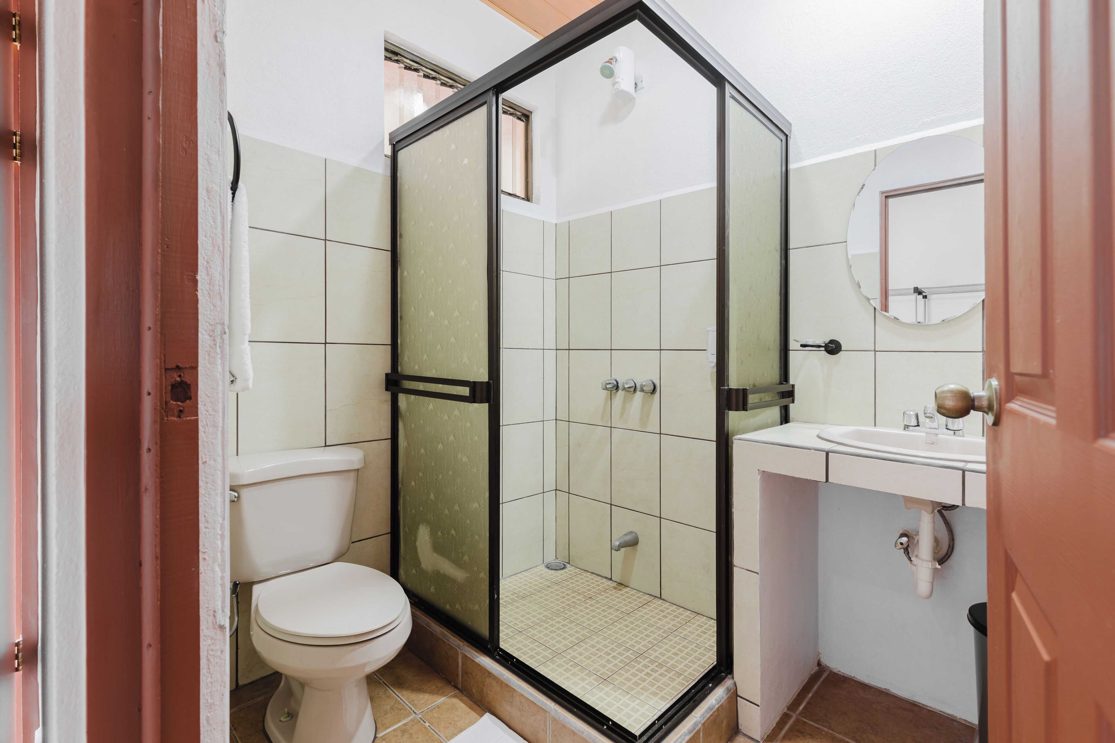 Un baño con inodoro, cabina de ducha e lavabo con espejo.