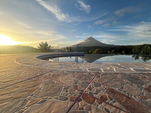 A stone-tiled infinity pool with a glass bridge leading to a mountain view. - Blue Mountain Lodging Arenal (Monterrey)