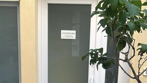 Un edificio con una puerta que dice "A DUE PASSI DAL MARE" y un arbusto pequeño al frente.