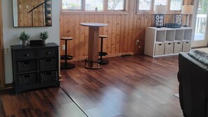 Una habitación con paredes de madera, una mesa de comedor, un sofá y un armario con cajas de almacenamiento.