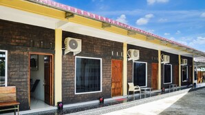 A hotel with a brick facade, multiple air conditioning units, and a covered outdoor seating area. - Hotel O Roda Inn (Padang)