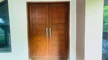 Puerta doble de madera con dos manijas, probablemente dando a una habitación o pasillo.