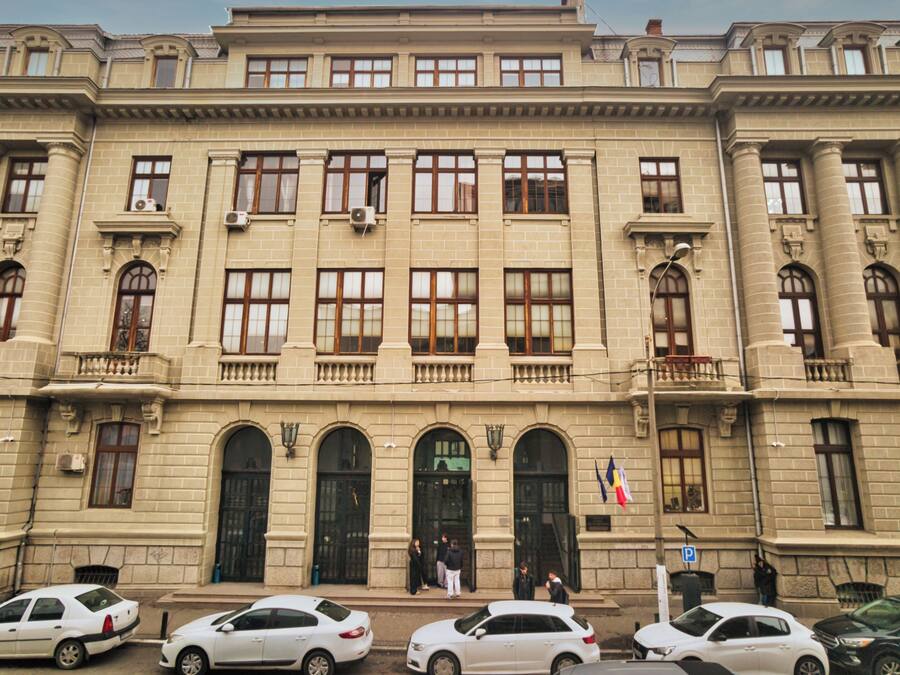 Un edificio grande de estilo clásico con múltiples ventanas y una entrada central.