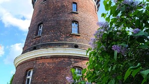 Una torre de ladrillo con techo redondeado, ventanas y una puerta.
