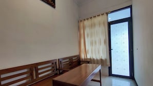 A room with a wooden bench, a table, and a door with a patterned glass panel. - OYO 95106 A Homestay Syariah (Sambi)