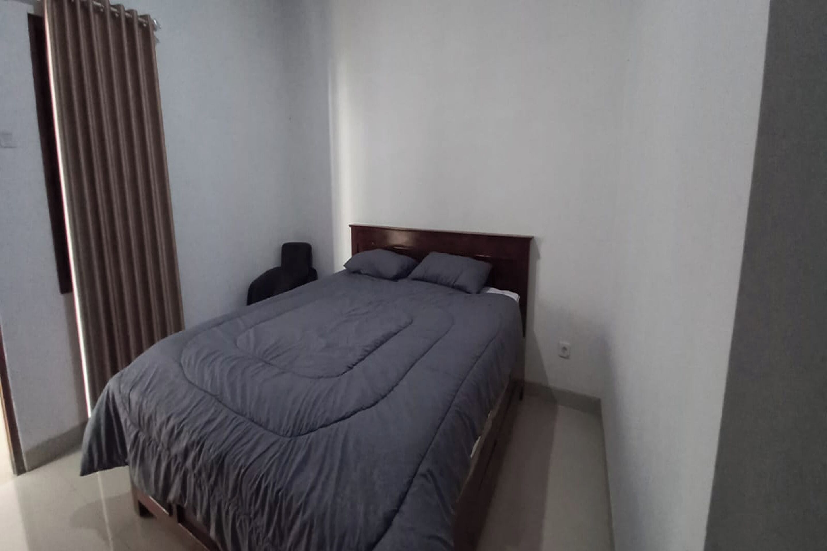 Ein Schlafzimmer mit Bett, Sessel und Heizkörper.