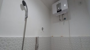 A bathroom with a shower, a water heater, and a wall-mounted towel rack. - OYO 95108 Nareswari Homestay Syariah (Nogosari)