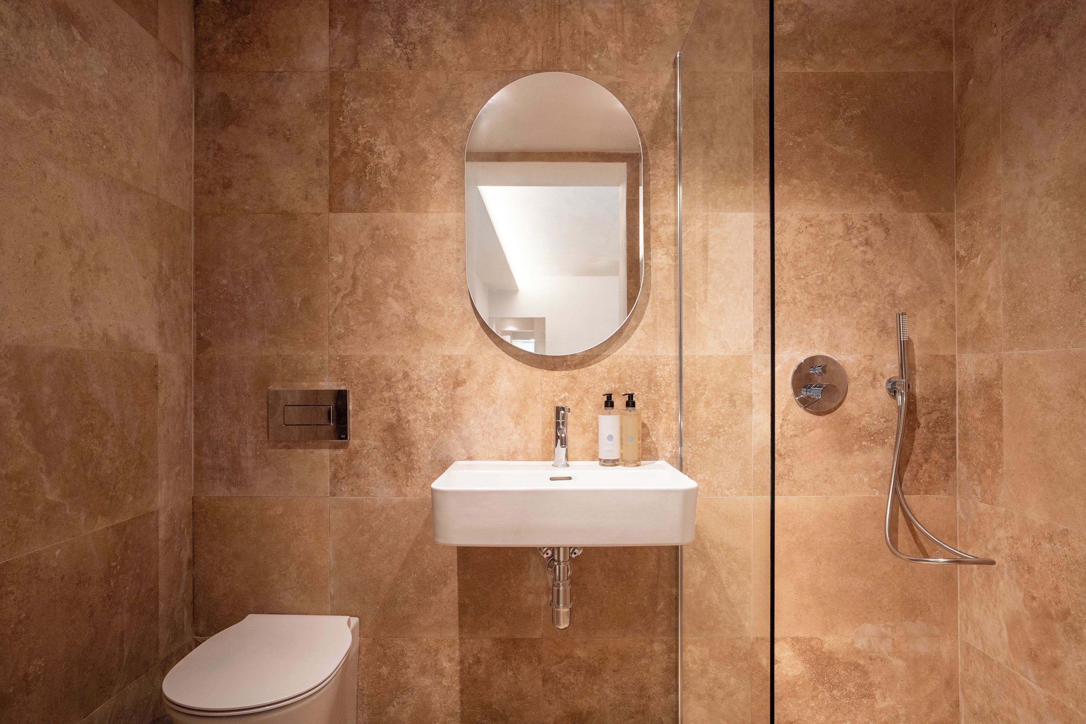 Ein Badezimmer mit einem weißen Waschbecken, Spiegel und Dusche.