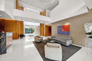 A spacious lobby with a reception desk, seating area, and a large window. - 2-bedroom apartment in charming West Hollywood with AC and gym access (West Hollywood)
