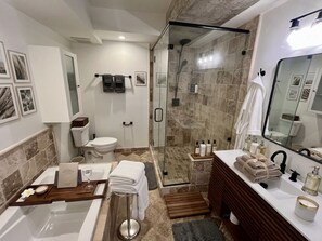 A modern bathroom with a glass-enclosed shower, a bathtub, a vanity with a mirror, and a toilet. - 2-bedroom apartment in charming West Hollywood with AC and gym access (West Hollywood)