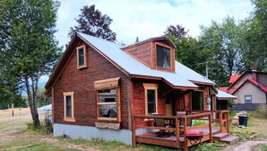 A wooden cabin with a porch, a small deck, and a metal roof. - Rustic cabin built 1880s on the Clark Fork River (Clark Fork)