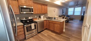 A kitchen with wooden cabinets, stainless steel appliances, and a granite countertop.