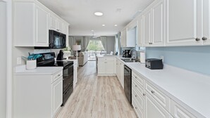 A modern kitchen with white cabinetry, a black microwave, and a coffee maker. - Private Heated Pool, Hot Tub, 1-min Walk to Beach, Pet Friendly, King Bed (Surfside Beach)