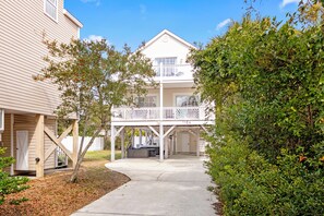A two-story house with a balcony, a covered porch, and a garage. - Private Heated Pool, Hot Tub, 1-min Walk to Beach, Pet Friendly, King Bed (Surfside Beach)