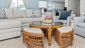 A living room with a sofa, two wicker chairs, a coffee table, and a striped armchair. - Private Heated Pool, Hot Tub, 1-min Walk to Beach, Pet Friendly, King Bed (Surfside Beach)
