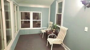 A room with a dark floor, a dining table with chairs, and a potted plant. -  Beautiful 3-bedroom 3 bath home  in the quaint fishing village of Engelhard. (Engelhard)