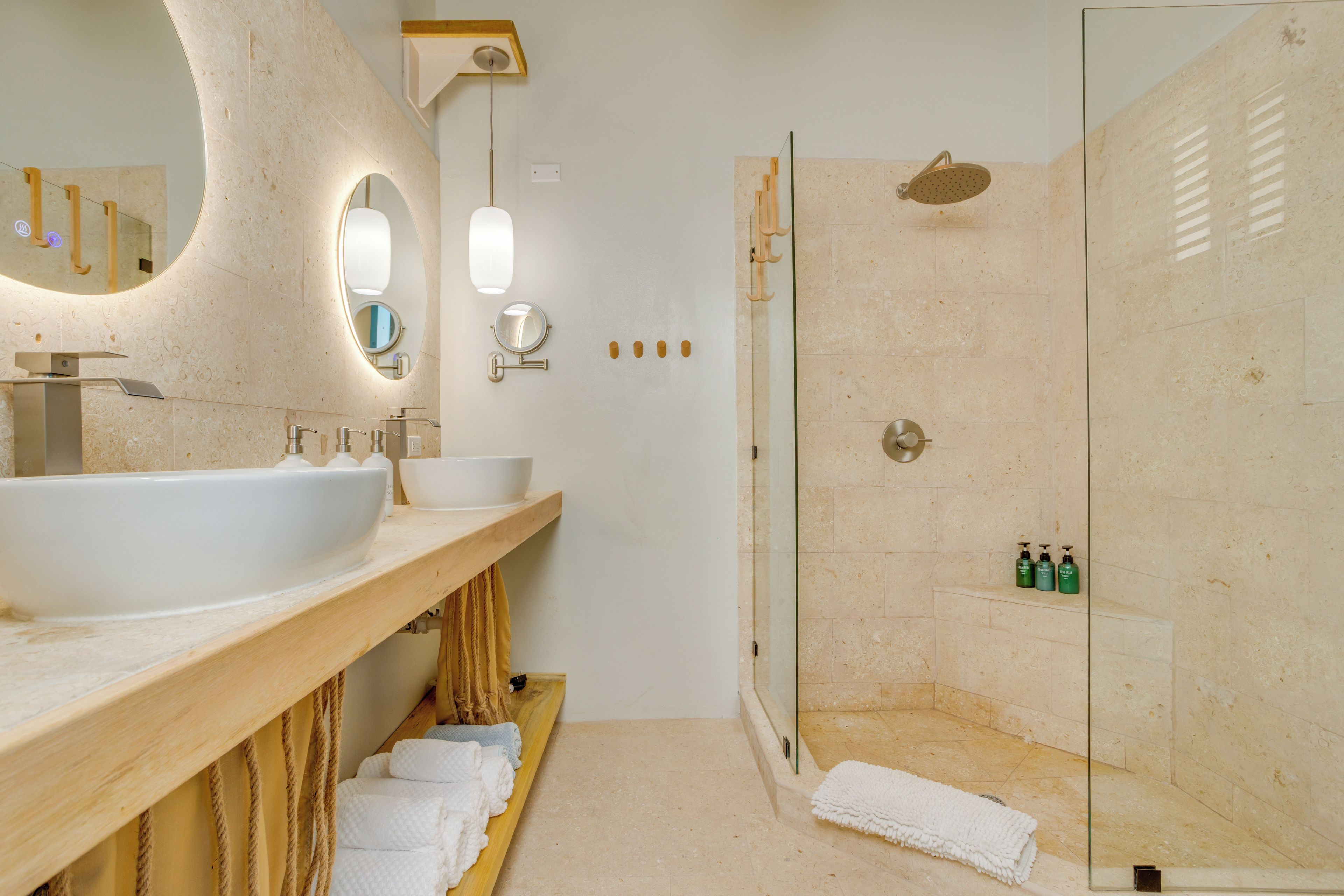 A modern bathroom with a large sink, mirror, and shower.