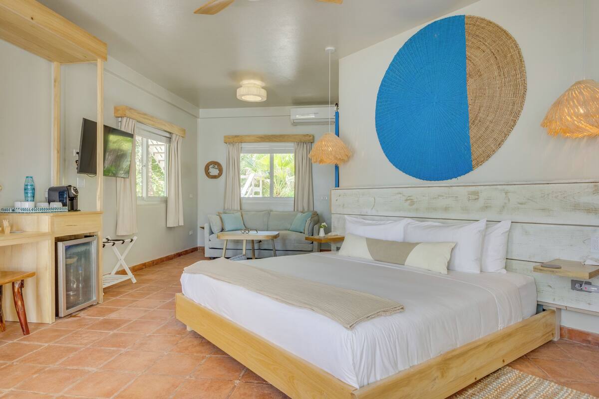 A bedroom with a bed, a desk, a chair, and a TV.