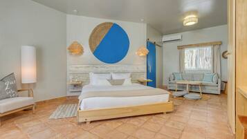 A bedroom with a bed, bedside tables, a sofa, a wall with a circular design, and a window with curtains.